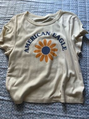 American Eagle Outfitters Cream Tee with Orange Daisy and Blue Logo Arc